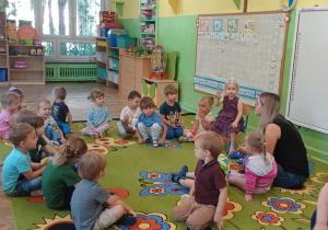 Dzieci wspólnie składają dziewczynce życzenia urodzinowe.