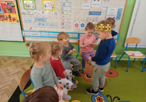 Chłopiec częstuje dzieci cukierkami