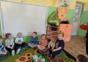 Chłopiec siedzi z koroną i prezentami