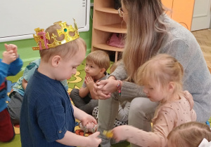 Chłopiec rozdaje cukierki dzieciom