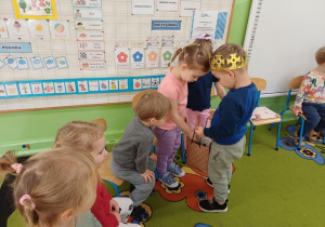 Chłopiec częstuje dzieci cukierkami