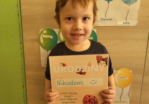 Chłopiec stoi z dyplomem