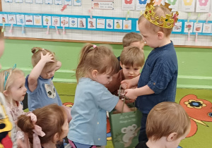 Chłopiec rozdaje cukierki dzieciom