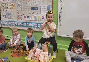 Chłopiec siedzi w koronie wśród dzieci