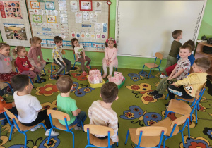 Dziewczynka siedzi z dziećmi w kole