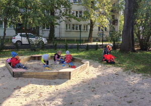 Dzieci bawią się w piaskownicy.