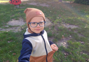 Chłopiec uśmiecha się do zdjęcia.