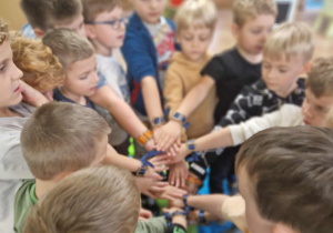 Chłopcy prezentują bransoletki od koleżanek