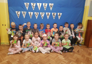 Dzieci pozują do zdjęcia na tle napisu dzień chłopaka