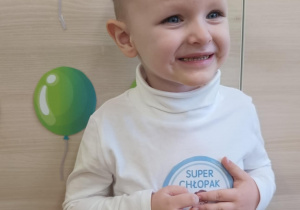 Chłopiec stoi z napisem Super chłopak