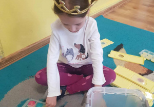 Jubilatka układa kolorowe kostki.