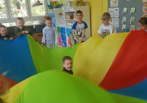 Chłopiec -jubilat na chuście animacyjnej.. Zabawy z chustą