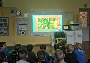 Dzieci oglądają film edukacyjny na tablicy interaktywnej