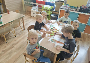 Dzieci malują farbami drzewo