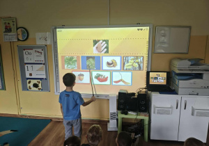 Chłopiec wykonuje zadanie na tablicy multimedialnej