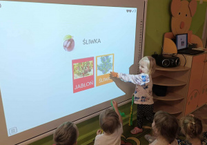 Dzieci wykonują zadanie na tablizy interaktywnej