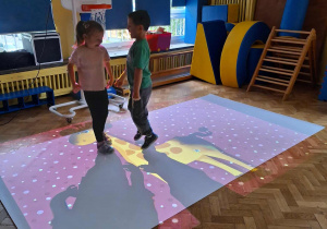 Dzieci wykonują adanie na podłodze interaktywnej
