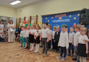 Dzieci w strojach galowyvh recytują wiersz
