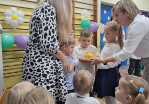 Dzieci starsze wręczają jabłka Pani