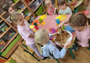 Starszaki częstują młodszych kolegów ciastem