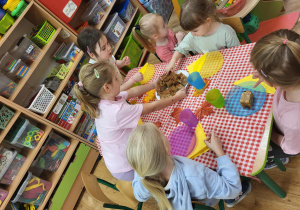 Starszaki częstują młodszych kolegów ciastem