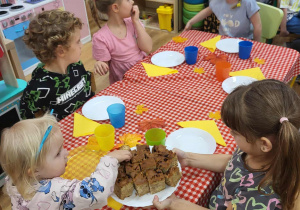Starszaki częstują młodszych kolegów ciastem