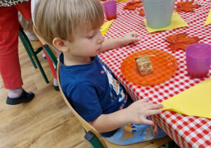 Dzieci siedzą przy stole i degustują owocowe ciasto