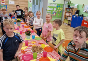 Dzieci prezentują pięknie przygotowany stół na przyjęcie