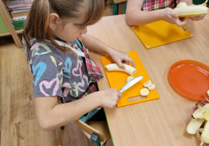 Dziewczynka kroi banana