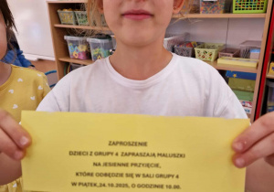 Dziewczynka prezentuje treść zaproszenia na przyjęcie