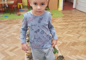 Chłopiec chodzi boso po ścieżce sensorycznej.