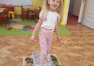 Dziewczynka chodzi boso po ścieżce sensorycznej.