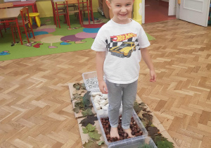 Chłopiec chodzi boso po ścieżce sensorycznej.