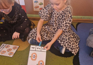 Dziewczynka przelicza dynie na obrazku