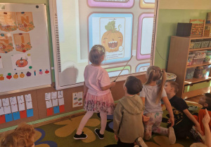 Dziewczynka wykonuje zadanie na tablizy interaktywnej