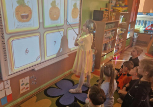 Dziewczynka wykonuje zadanie na tablizy interaktywnej