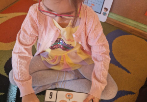 Dziewczynka przelicza dynie na obrazku