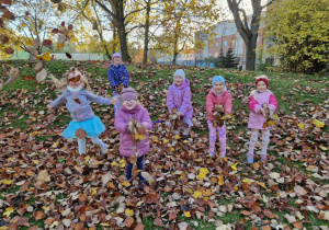 Dziewczynki podrzucają kolorowe liście