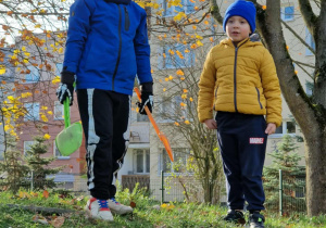 Chłopcy grabią liście na górce