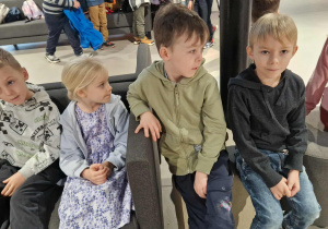 Dzieci siedzą na kanapach w oczekiwaniu na spektakl