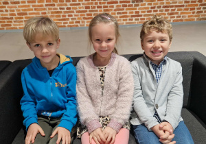 Dzieci siedzą na kanapach w oczekiwaniu na spektakl