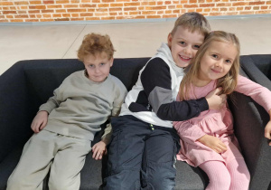 Dzieci siedzą na kanapach w oczekiwaniu na spektakl