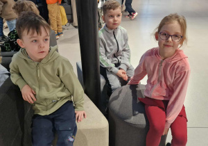 Dzieci siedzą na kanapach w oczekiwaniu na spektakl