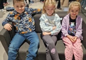 Dzieci siedzą na kanapach w oczekiwaniu na spektakl