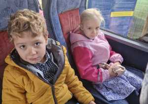 Dziewczynka i chlłopiec siedzą w autokarze