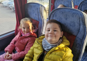 Dziewczynka i chlłopiec siedzą w autokarze