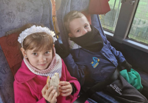 Dziewczynka i chlłopiec siedzą w autokarze