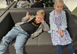 Dzieci siedzą na kanapach w oczekiwaniu na spektakl