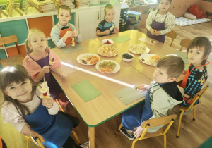 Dzieci nadziewaja owoce na patyki szaszłykowe