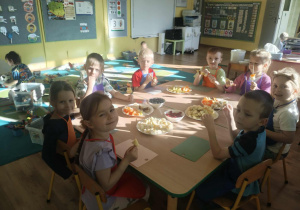 Dzieci nadziewaja owoce na patyki szaszłykowe